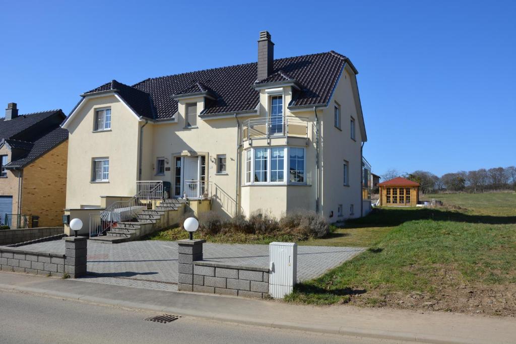 una grande casa bianca sul lato di una strada di B&B De Boerderij a Berdorf