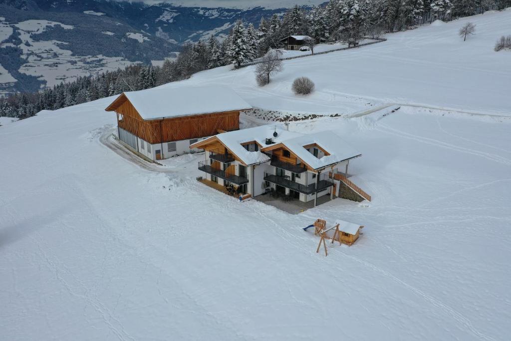 eine Luftansicht eines Hauses im Schnee in der Unterkunft Platiederhof in Lajen