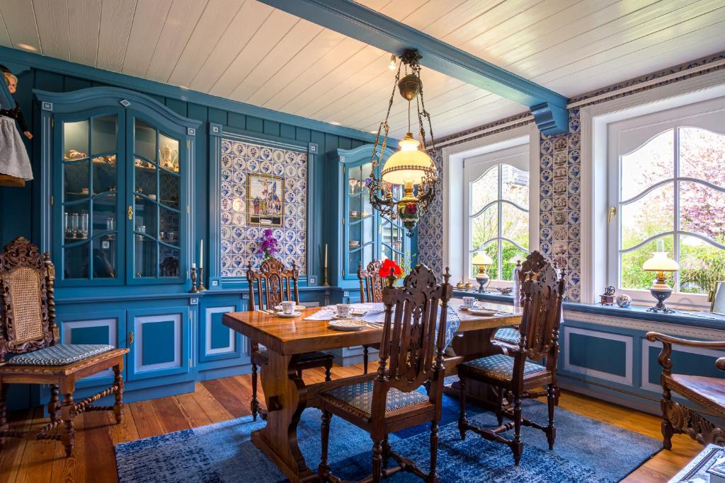 een eetkamer met blauwe muren en een tafel en stoelen bij Inselhotel Arfsten in Wyk auf Föhr