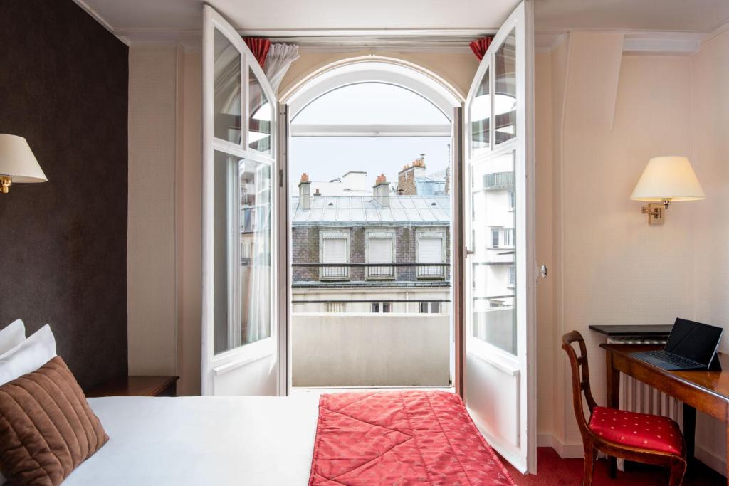 Zimmer mit einem Bett, einem Schreibtisch und einem Fenster in der Unterkunft Abaca Messidor by Happyculture in Paris