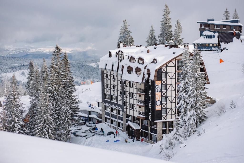 un bâtiment recouvert de neige au sommet d'une montagne dans l'établissement Hotel Lavina, à Jahorina