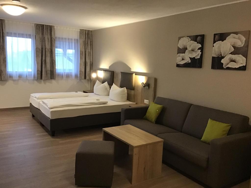 pokój hotelowy z łóżkiem i kanapą w obiekcie Gasthof Hotel Esterer w mieście Rosenheim