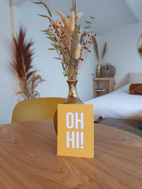 un vase sur une table avec un panneau sur celui-ci dans l'établissement Little Lodge Noordwijk aan Zee, à Noordwijk