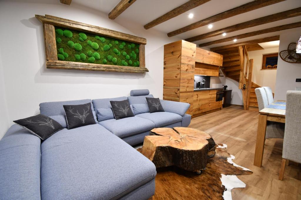 - un salon avec un canapé bleu et une table dans l'établissement Chalet Apartments Maštal, à Železná Ruda