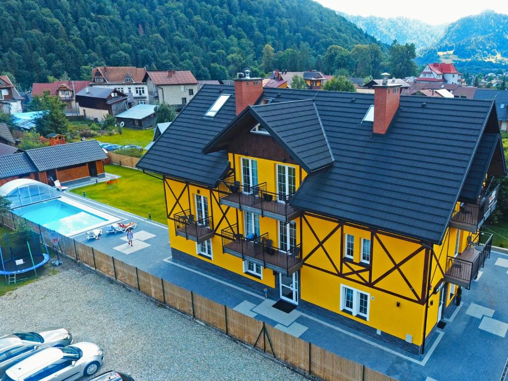 una casa gialla con tetto nero e piscina di Willa Szczepaniakówka a Szczawnica