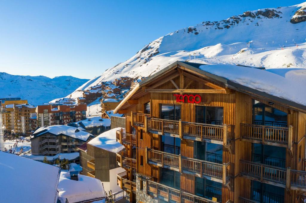 ein Hotel mit einem schneebedeckten Berg im Hintergrund in der Unterkunft Langley Hôtel Tango in Val Thorens