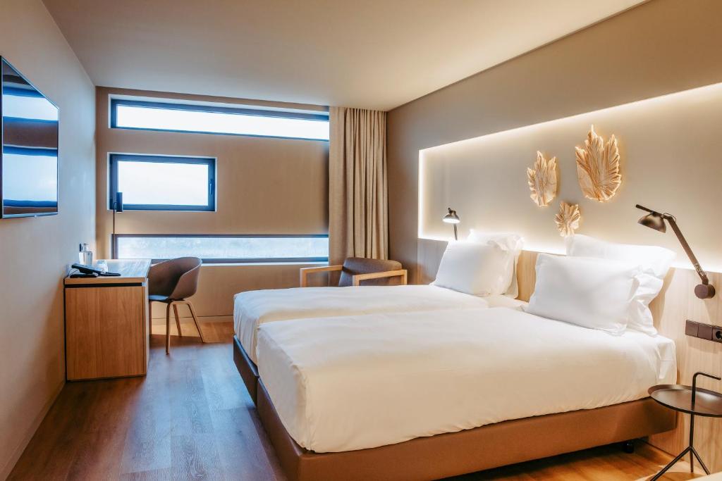 Habitación de hotel con cama grande y escritorio. en Mercure Fátima, en Fátima