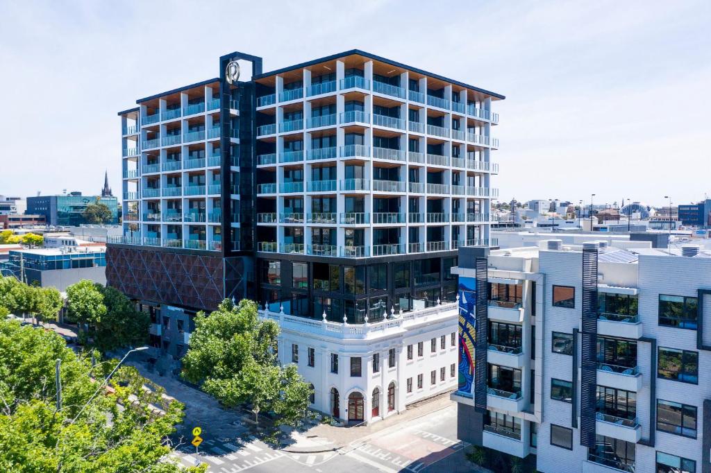 un edificio de oficinas con un reloj encima en R Hotel Geelong, en Geelong