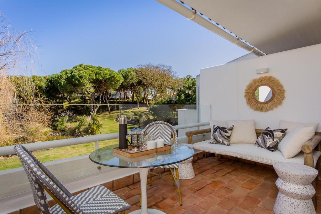 une terrasse avec un canapé, une table et des chaises dans l'établissement M&M Home, à Quinta do Lago