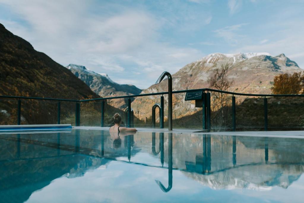 een vrouw in een plas water in de bergen bij Hotel Union Geiranger Bad & Spa in Geiranger