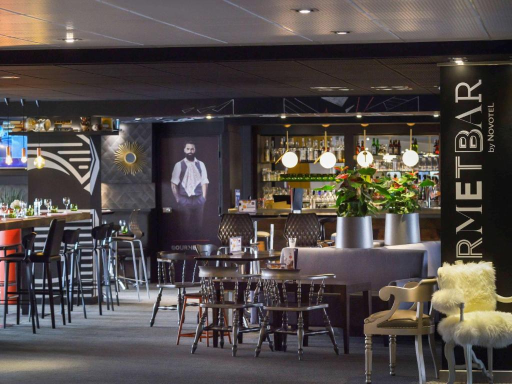 un restaurante con mesas y sillas y un bar en Novotel Metz Centre, en Metz