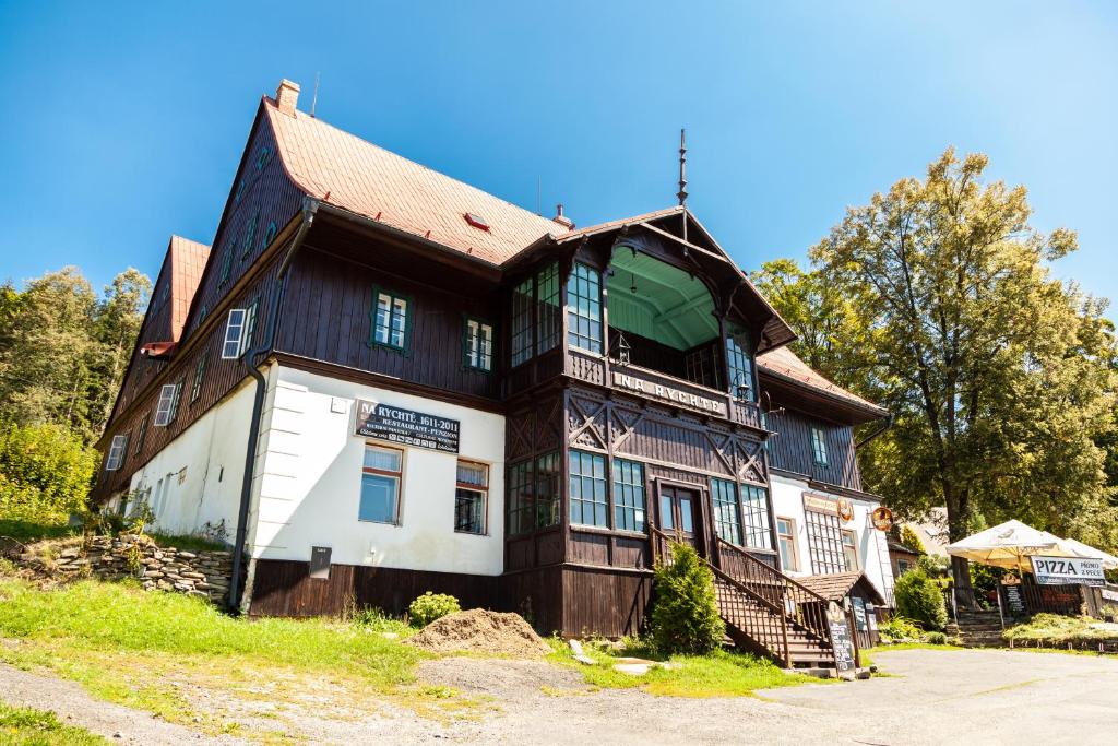 une grande maison en bois au sommet d'une colline dans l'établissement Penzion Na Rychtě, à Malá Morávka