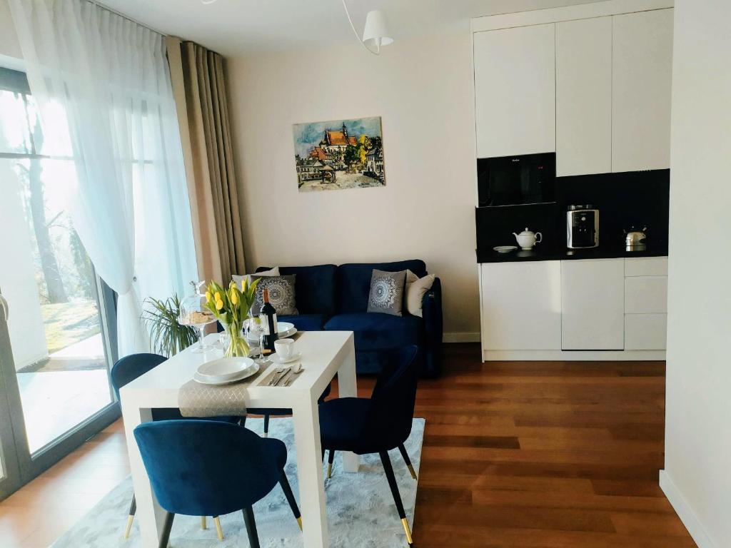 a living room with a table and a blue couch at Apartamenty RÓŻANA 2 in Nałęczów