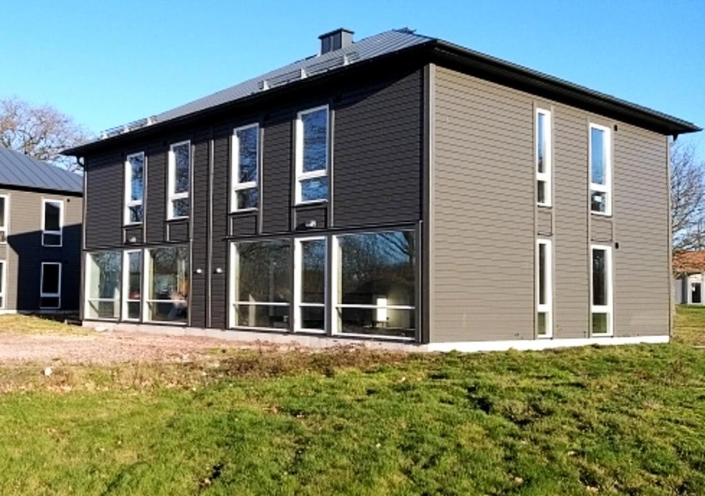 a house with a black and gray exterior at Saxnäs Ferieboende L. Erik in Färjestaden