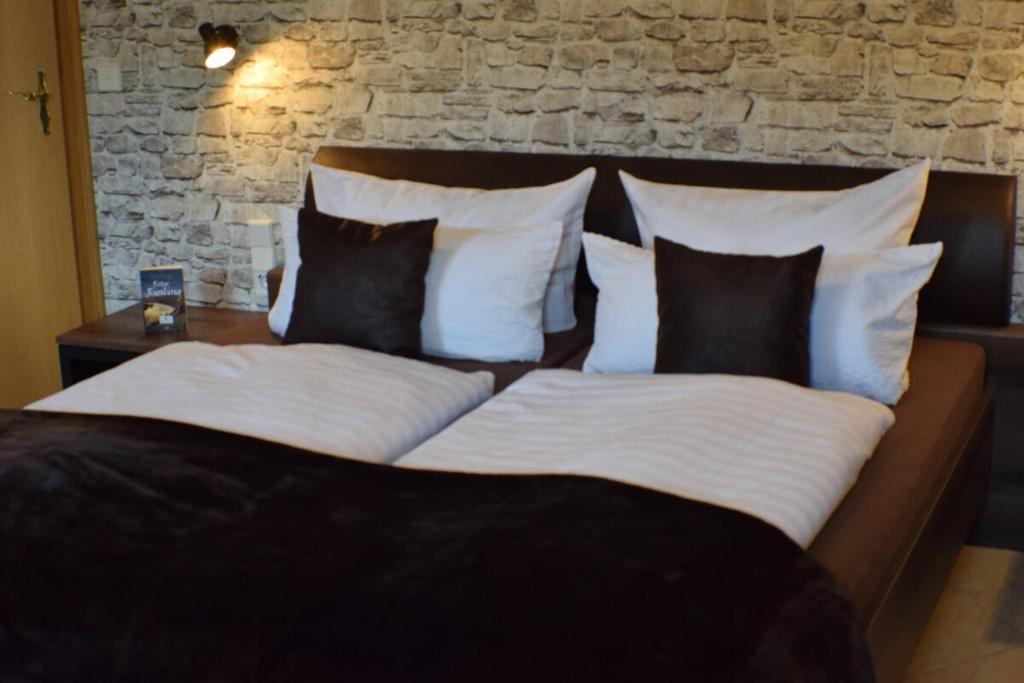 a bedroom with a bed with white sheets and pillows at Bachmeier's Gasthaus Traube Niederfell in Niederfell