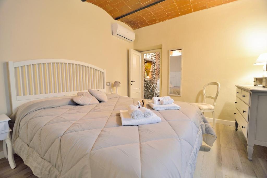 een slaapkamer met een groot bed en handdoeken bij Borgo in Città in Pistoia