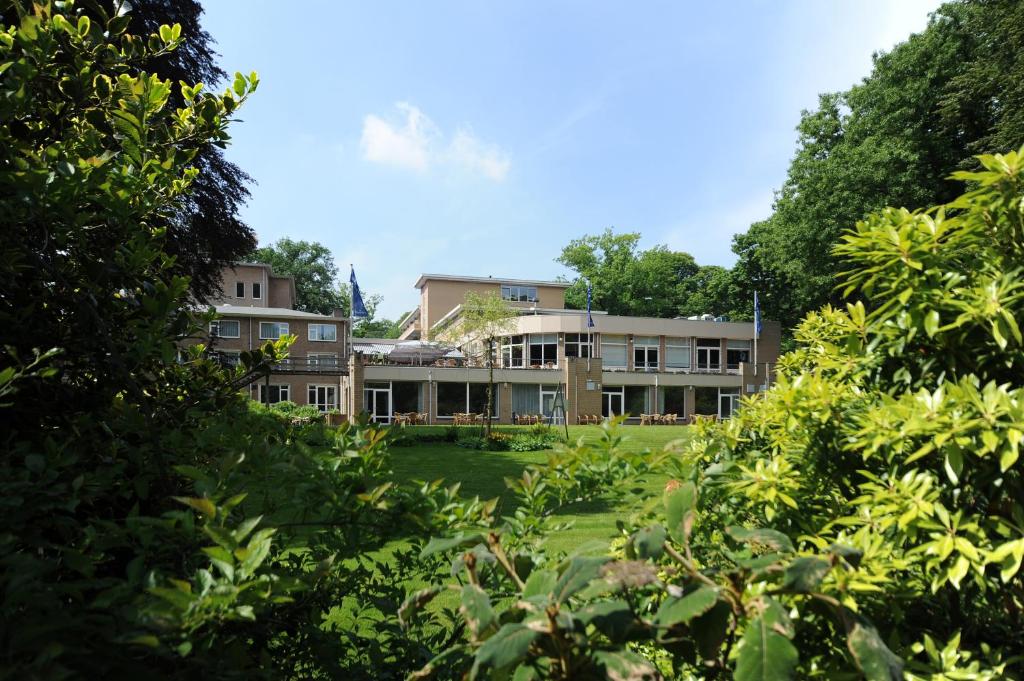 een uitzicht op een gebouw met bomen bij Fletcher Parkhotel Val Monte in Berg en Dal