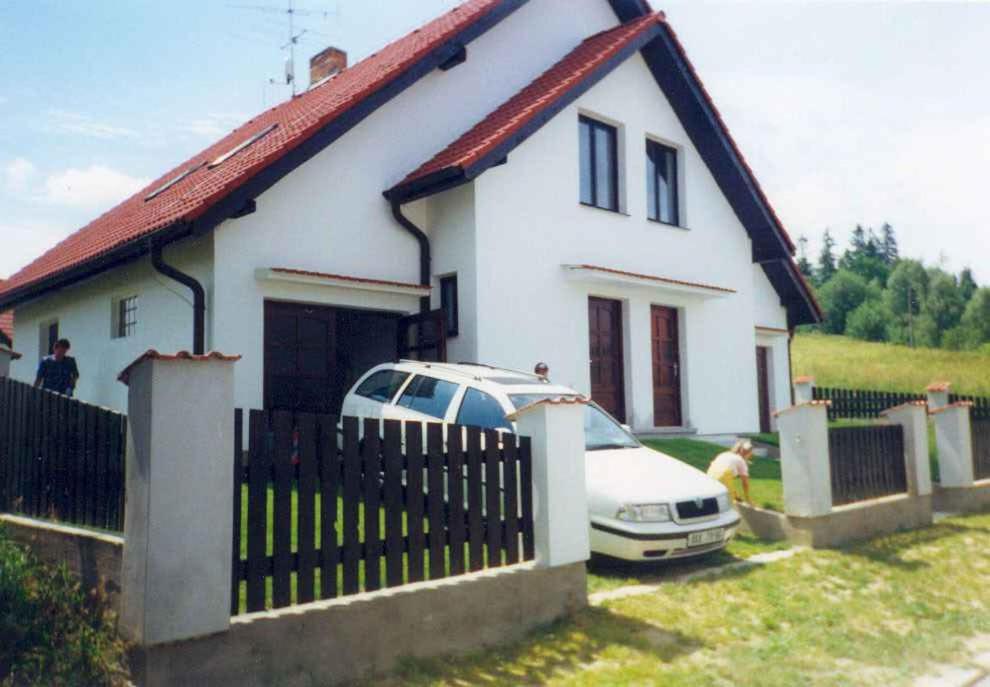 een wit huis met een auto ervoor geparkeerd bij Holiday home in Cerna v Posumavi 1908 in Černá v Pošumaví