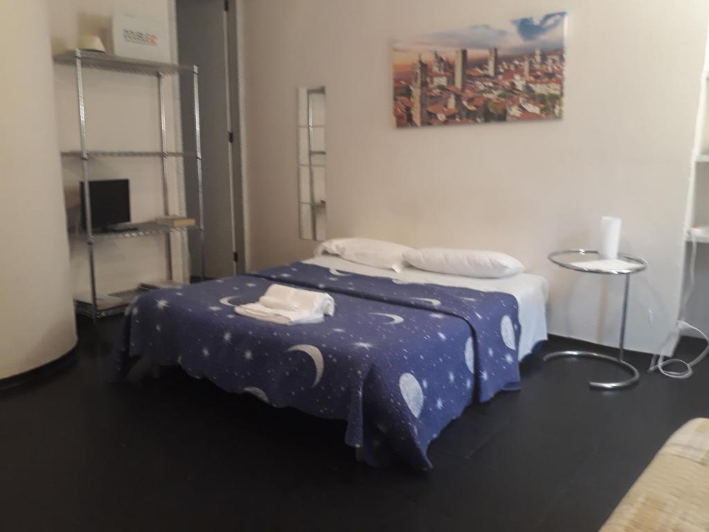 um quarto com uma cama com um edredão azul em Romeo and Juliet Apartaments em Bérgamo