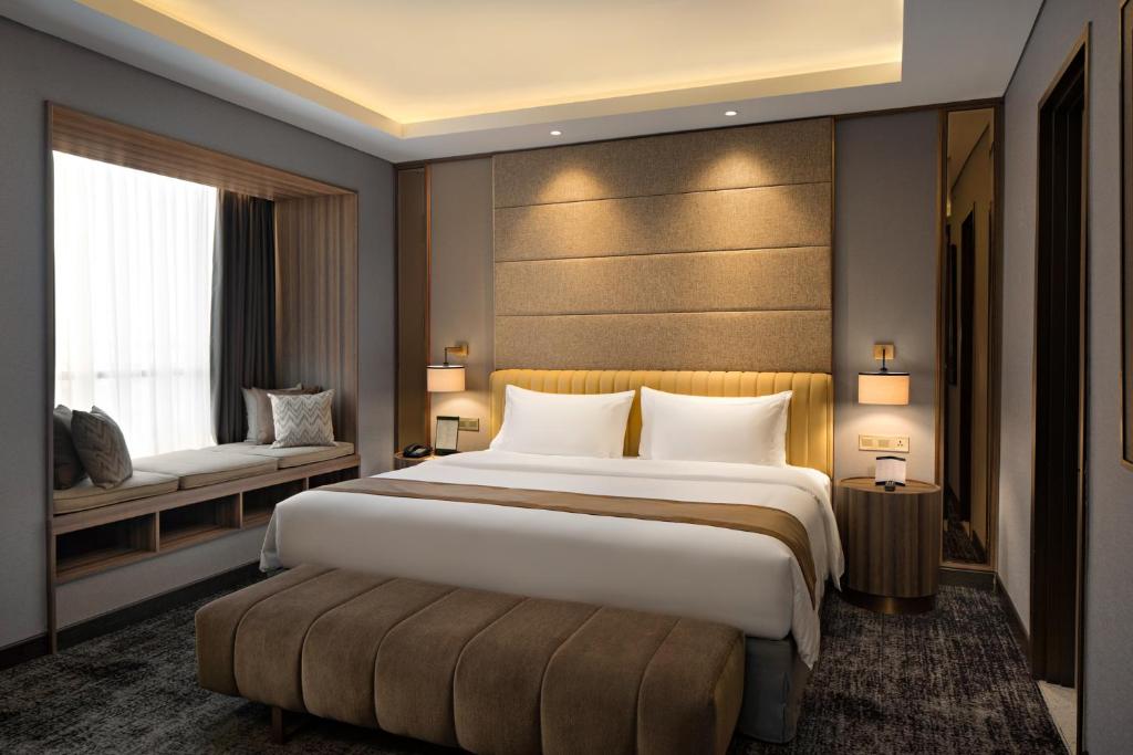 a hotel room with a large bed and a window at Sutasoma Hotel in Jakarta