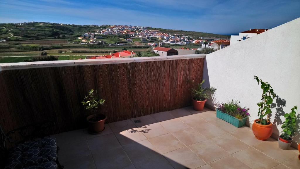 balkon z doniczkami na boku budynku w obiekcie Areias Sunset Suite w mieście Lourinhã