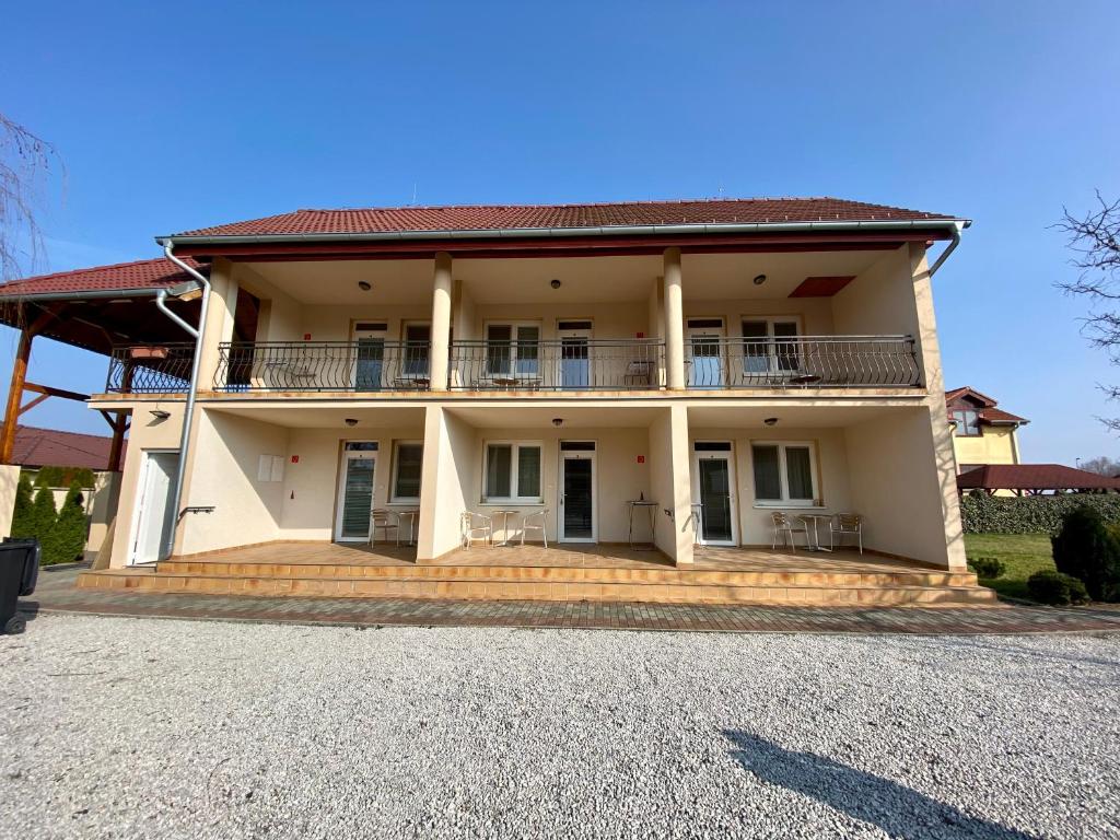 una grande casa con portico e balcone di Apartmánový dom Flóra a Veľký Meder