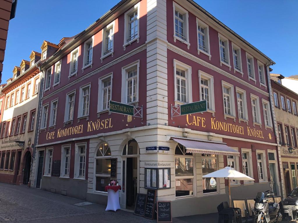 un edificio con dos personas de pie delante de él en Café & Hotel Knösel, en Heidelberg