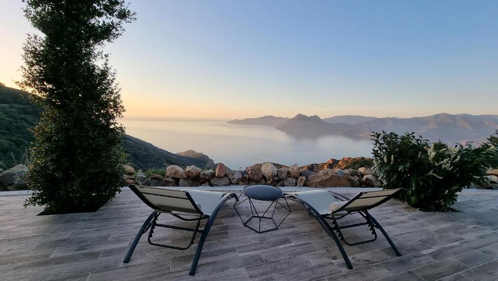 uma mesa e cadeiras num pátio com vista para o oceano em Résidence Le Bella Vista em Piana