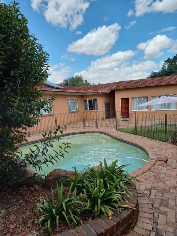 una piscina en el patio trasero de una casa en Amberlight Self Catering Accommodation, en Krugersdorp