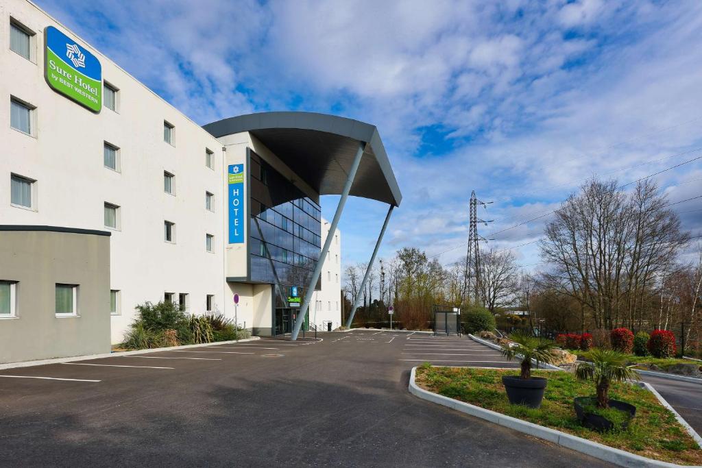 un edificio con un parcheggio di fronte di Sure Hotel by Best Western Nantes Beaujoire a Nantes