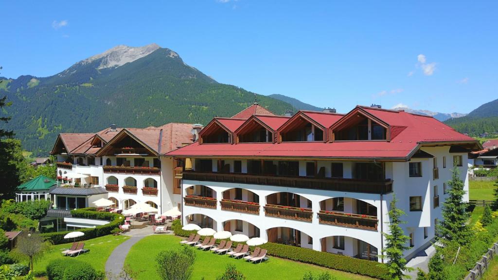 um grande hotel com uma montanha ao fundo em Hotel Alpen Residence em Ehrwald