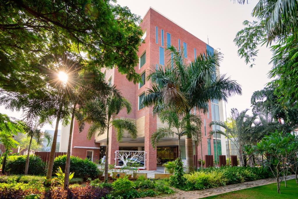 a building with palm trees in front of it at Welcomhotel by ITC Hotels, RaceCourse, Coimbatore in Coimbatore