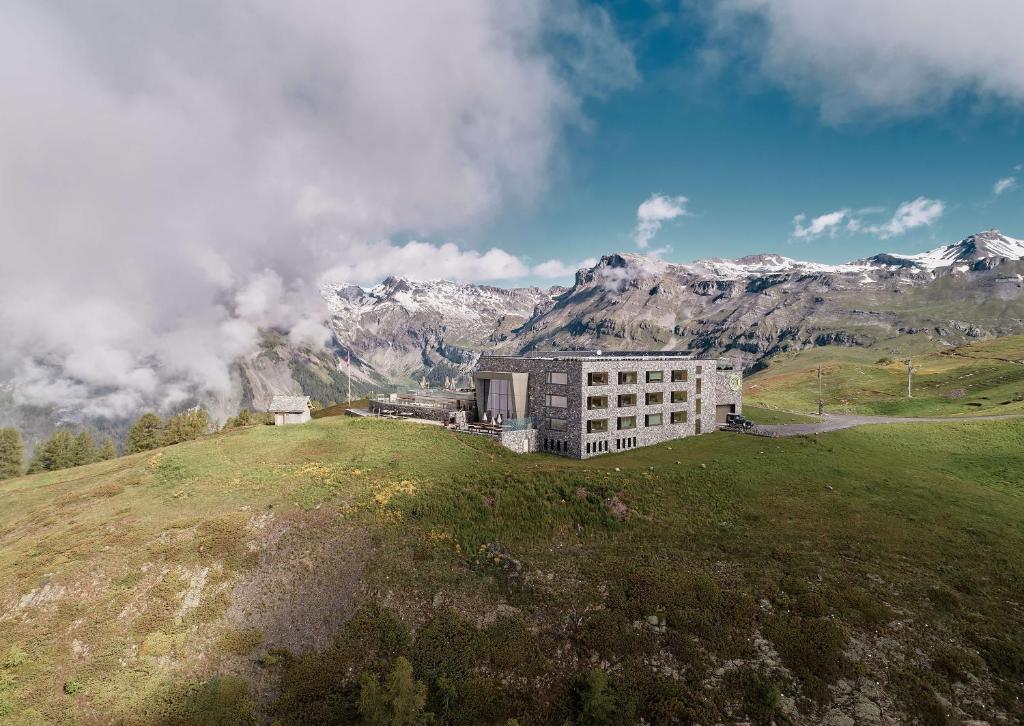 een gebouw op een heuvel met bergen op de achtergrond bij chetzeron in Crans-Montana