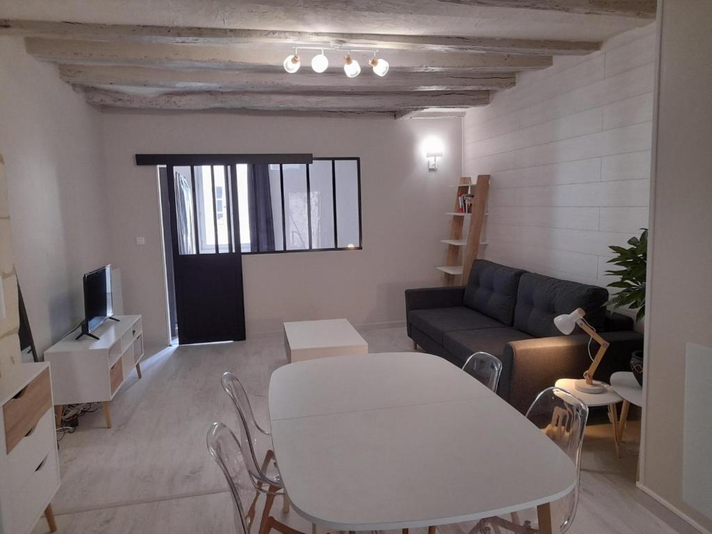 a living room with a white table and a couch at Le cosy d'Amboise in Amboise