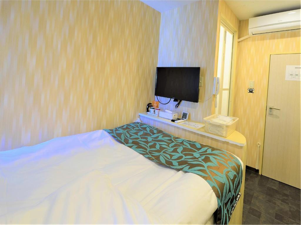 Tempat tidur dalam kamar di Nishifunabashi Ekimae Hotel