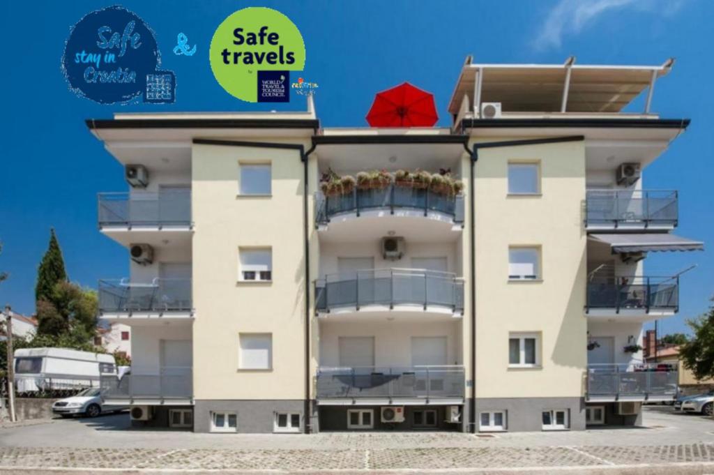 a building with a red umbrella on top of it at Apartments Babo in Rovinj