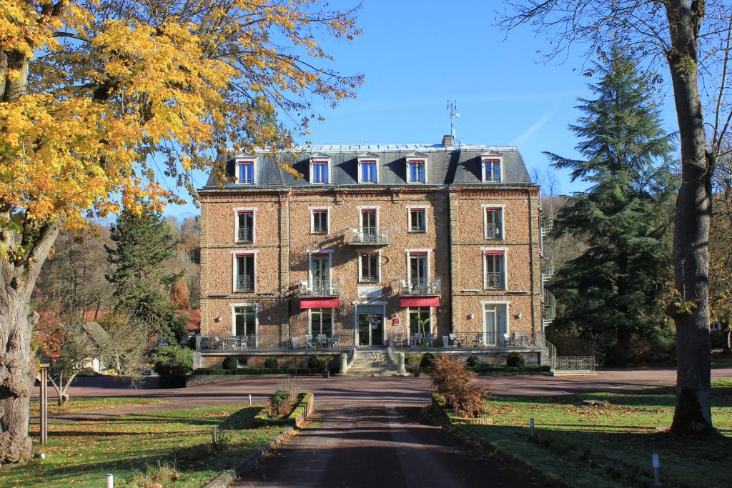 un gran edificio de ladrillo en una carretera en Logis Hôtel & Restaurant - Le Manoir de Sauvegrain, en Saint-Lambert