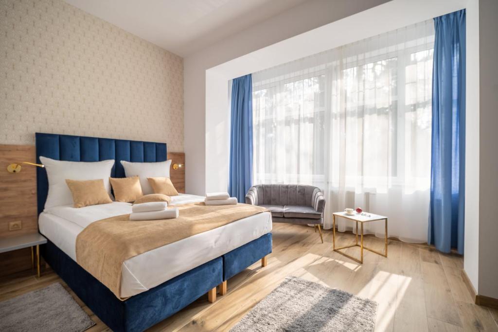 ein Schlafzimmer mit einem blauen Bett und einem großen Fenster in der Unterkunft Helios Aparthotel in Świnoujście