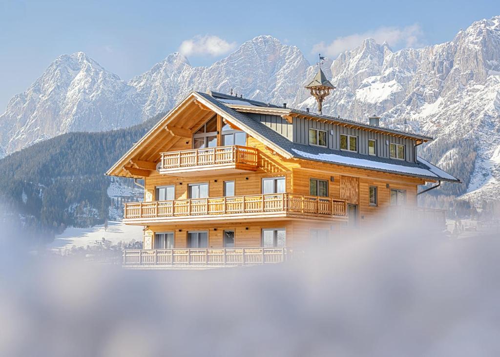 een houten huis in de bergen boven de wolken bij Alpin Residenz Dachsteinperle in Ramsau am Dachstein