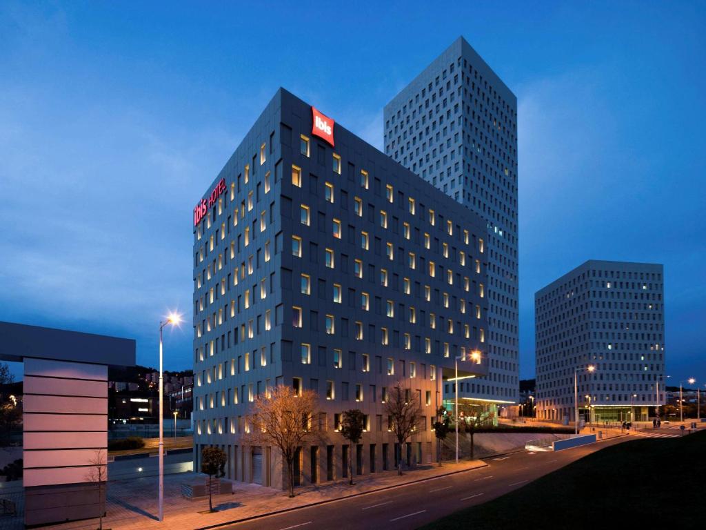 un edificio alto con un cartel encima en Ibis Barcelona Santa Coloma, en Santa Coloma