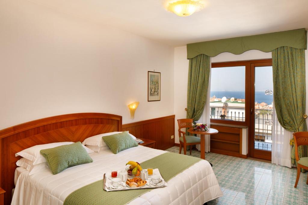 una camera d'albergo con un letto e un vassoio di cibo sopra di Grand Hotel Cesare Augusto a Sorrento