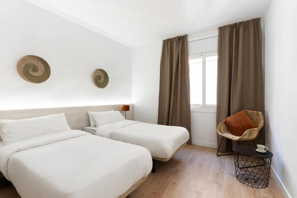 ein Hotelzimmer mit 2 Betten und einem Fenster in der Unterkunft Apartamentos Venecia in Lloret de Mar