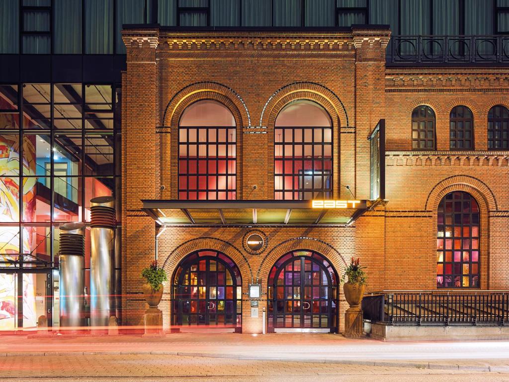 ein Backsteingebäude mit vielen Fenstern auf einer Straße in der Unterkunft east Hotel Hamburg in Hamburg