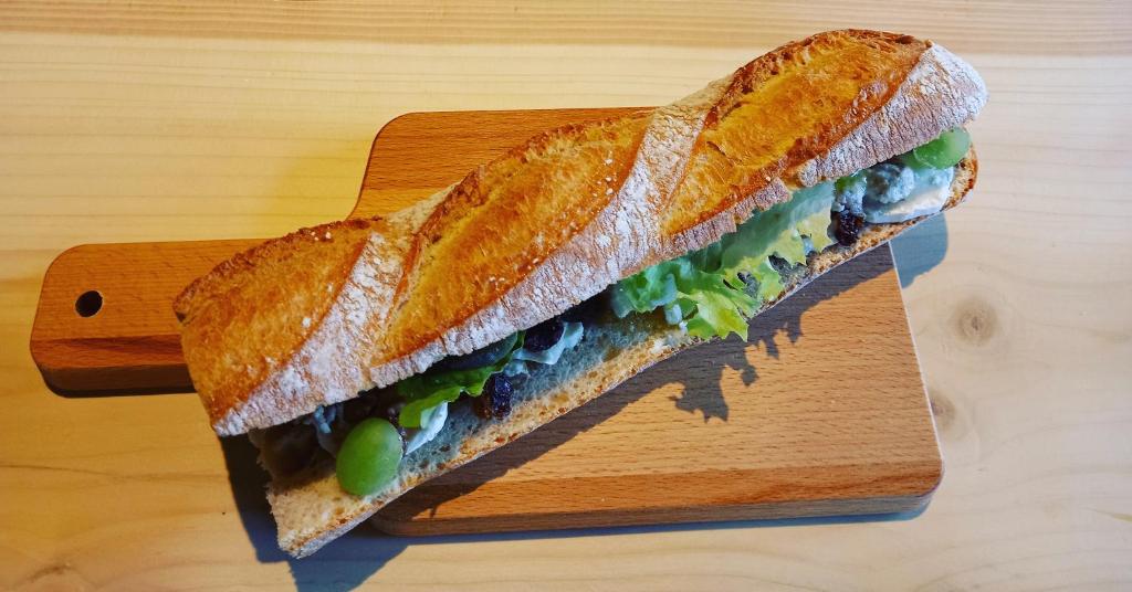 un sandwich sur une planche de découpe sur une table dans l'établissement Renée Cense, à Houffalize