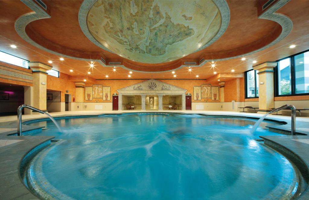 ein großer Pool in einem Gebäude mit großer Decke in der Unterkunft Villa Quaranta Tommasi Wine Hotel & SPA in Pescantina