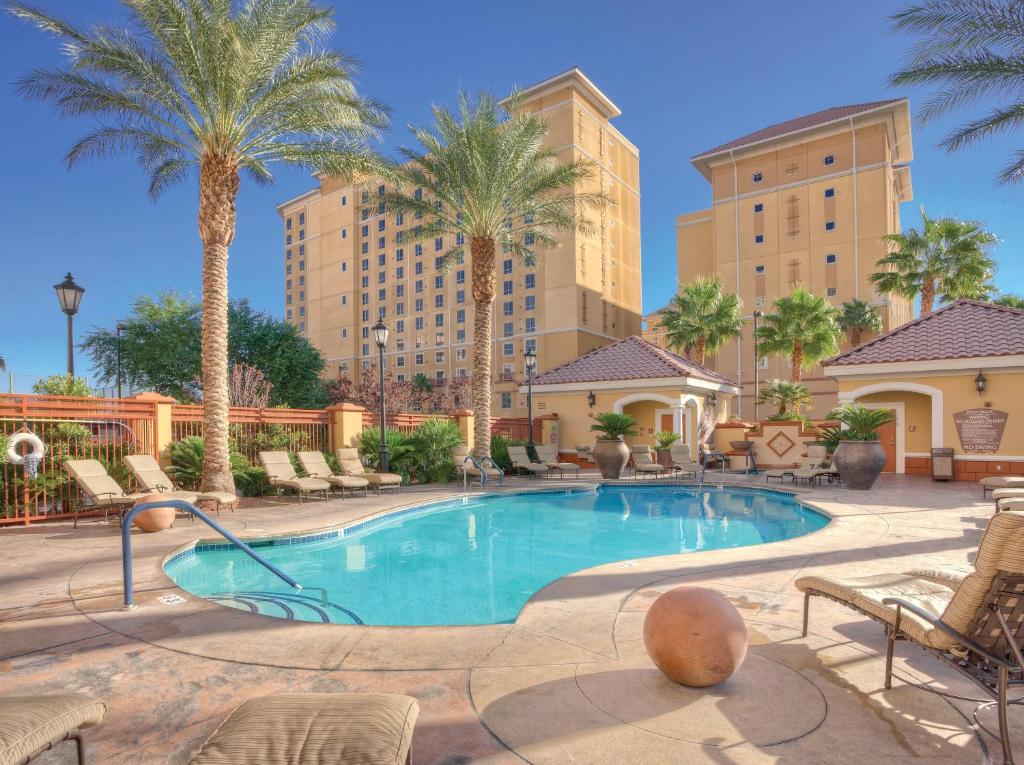 uma piscina com palmeiras e edifícios em Club Wyndham Grand Desert em Las Vegas