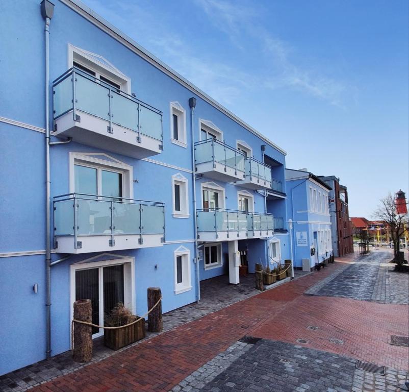 een blauw gebouw met balkons in een straat bij Hotel Alter Muschelsaal in Büsum