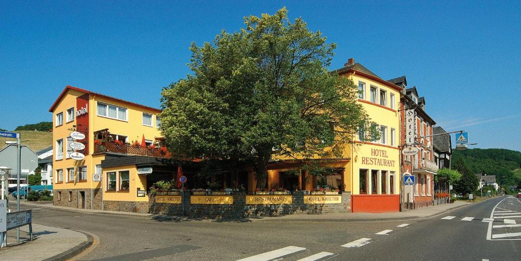 un bâtiment avec un arbre sur le côté d'une rue dans l'établissement Hotel Weinhaus Kreuter, à Coblence