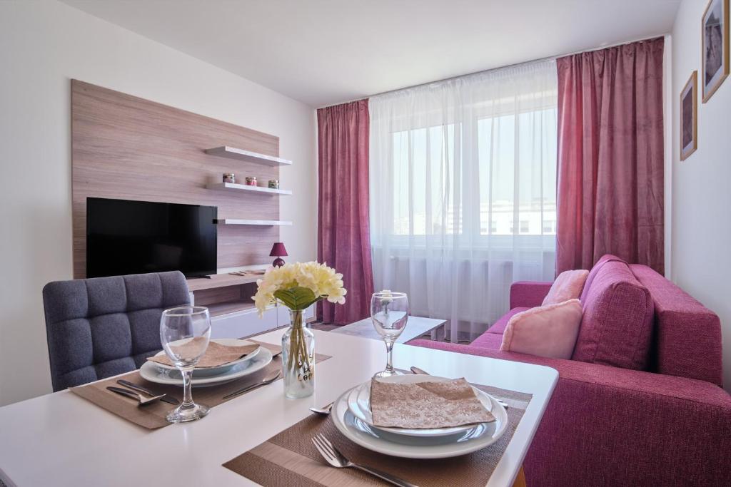 sala de estar con mesa y sillas moradas en 111Apartments, en Košice