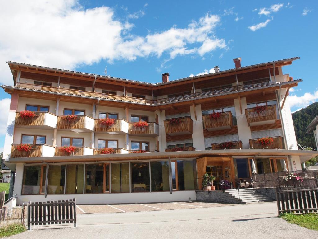 a large building with flower boxes on the balconies at Sporthotel Rasen in Rasùn di Sotto